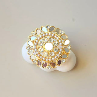 Decorative ring with gold and pearl design on a light background