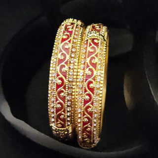 Gold and red bangles on a black background