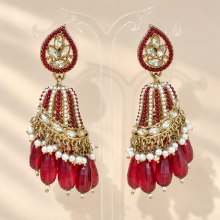 Adeline maroon red polki jhumka earrings with gold tone finish white pearl accents and deep red faceted bead drops on display