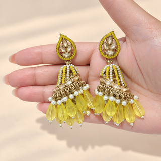 Adeline yellow gold finish polki jhumka earrings held in hand showing detailed dome and yellow bead tassels