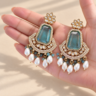 Beatrix pastel blue polki earrings 7.5 cm with gold finish and pearl drops shown in hand