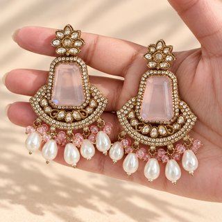 Beatrix pastel pink polki earrings 7.5 cm with gold finish and pearl drops shown in hand