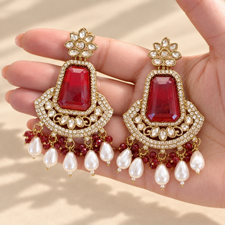 Beatrix red polki earrings 7.5 cm with gold finish, red bead accents and white pearl drops shown in hand