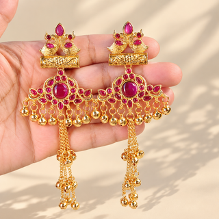 Claudine purple Kashmiri statement earrings in gold finish with decorative bird motifs and chain tassels held in hand