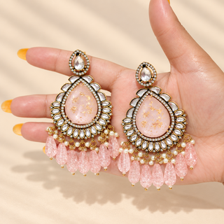 Clementina pink Indian artificial kundan earrings held in hand showing 9 cm statement size and blush pink drops