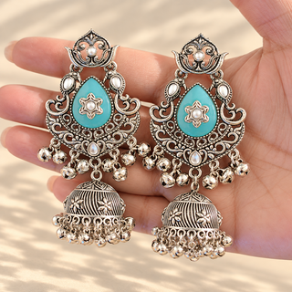 Cressida light blue oxidised silver jhumka earrings with blue teardrop kundan-style stones photographed in hand