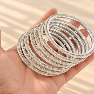 Euphrasia silver imitation bangles set of eight with pearly reflective details held in hand