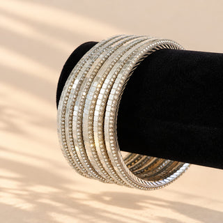 Euphrasia silver tone artificial bangles with crystal look detailing on black stand angled view