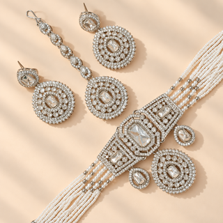 Florence silver polki choker necklace set with white pearl bead strands matching earrings and maang tikka flat lay