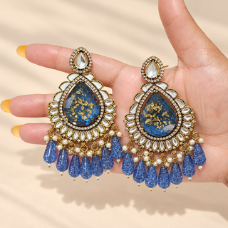 Lavinia 9 cm blue kundan chandelier earrings pair held in hand showing white kundan-style stones and blue teardrop beads