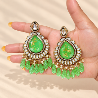 Lavinia 9 cm green kundan statement earrings held in hand with white decorative stones and green teardrop tassels