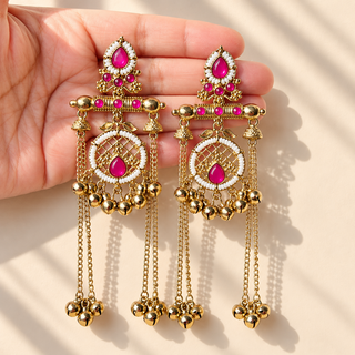 Ottilie hot pink Kashmiri earrings with Victorian gold finish held in hand