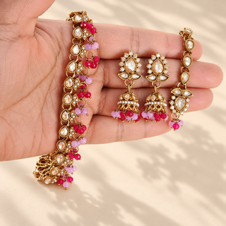 Raya lilac and rani pink Indian imitation polki necklace set close up on hand with earrings and tikka