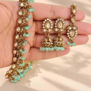 Close up Raya mint green polki necklace earrings and maang tikka with gold finish and mint bead drops