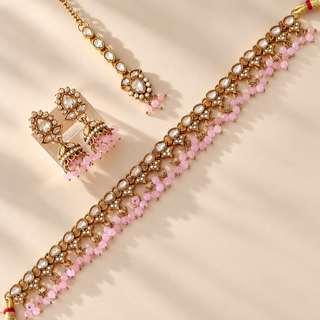 Raya pastel pink polki necklace set with matching gold finish jhumka earrings and maang tikka