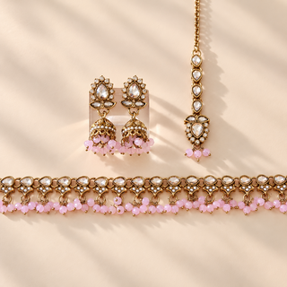 Raya pastel pink polki style artificial necklace set with earrings and maang tikka on beige background