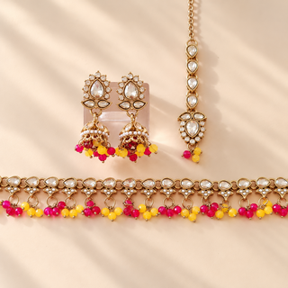 Raya yellow and rani pink Indian imitation jewellery set with 4.4 cm jhumka earrings and tikka on beige background