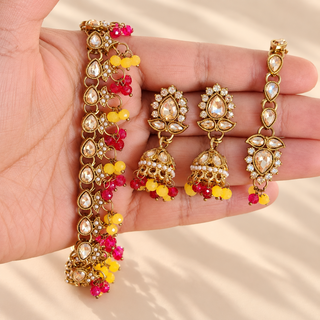 Raya yellow and hot pink artificial polki necklace set close up with gold finish jhumkas and maang tikka