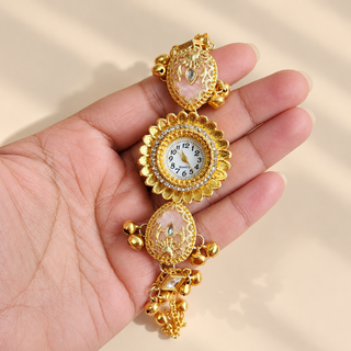 Rosalie Kashmiri gold watch with pink enamel and gold ghungroo bells shown in hand
