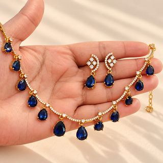 Imogen blue teardrop CZ diamond necklace and earrings displayed in hand