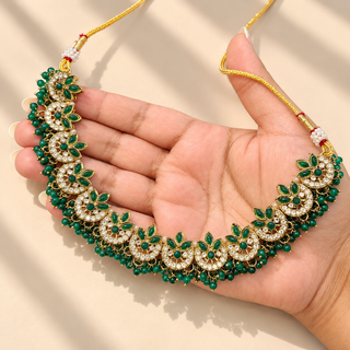 Rosamund green kundan Indian necklace with floral crescent motifs and green bead fringe held in hand