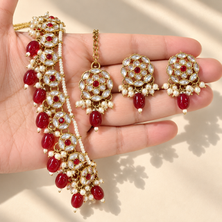 Winifred dark red kundan necklace set 3 cm earrings and matching maang tikka close up in hand